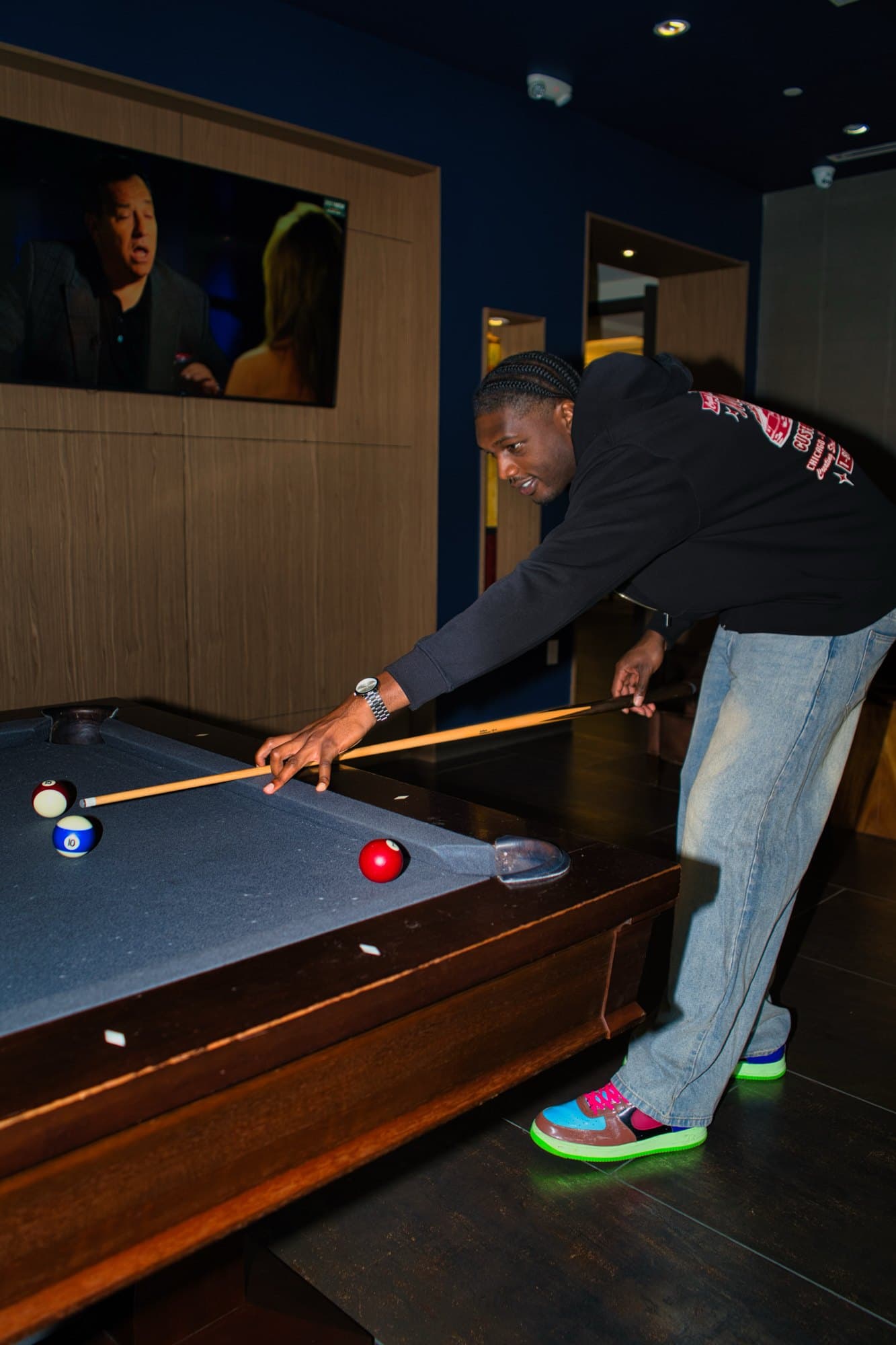 Lining up a shot on a blue felt pool table in a dim lounge